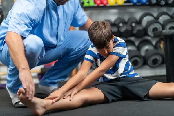 physical-therapist-instructing-a-young-boy-in-exer-2026-03-16-03-31-30-utc-69b7e58a8738f